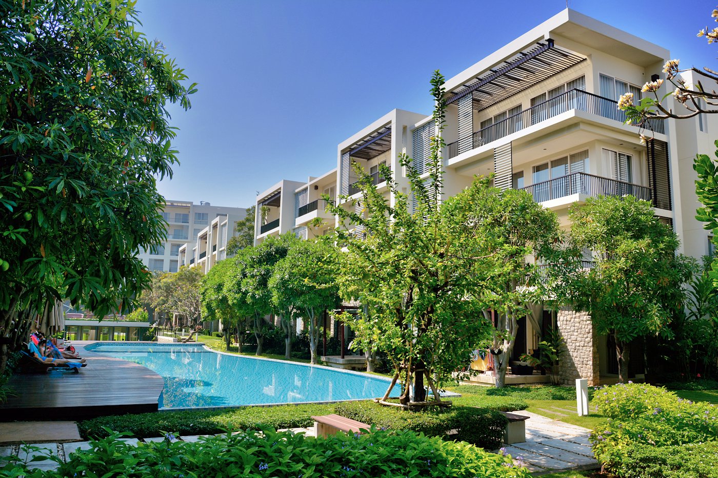 Swimming pool surrounded by trees in an apartment compound